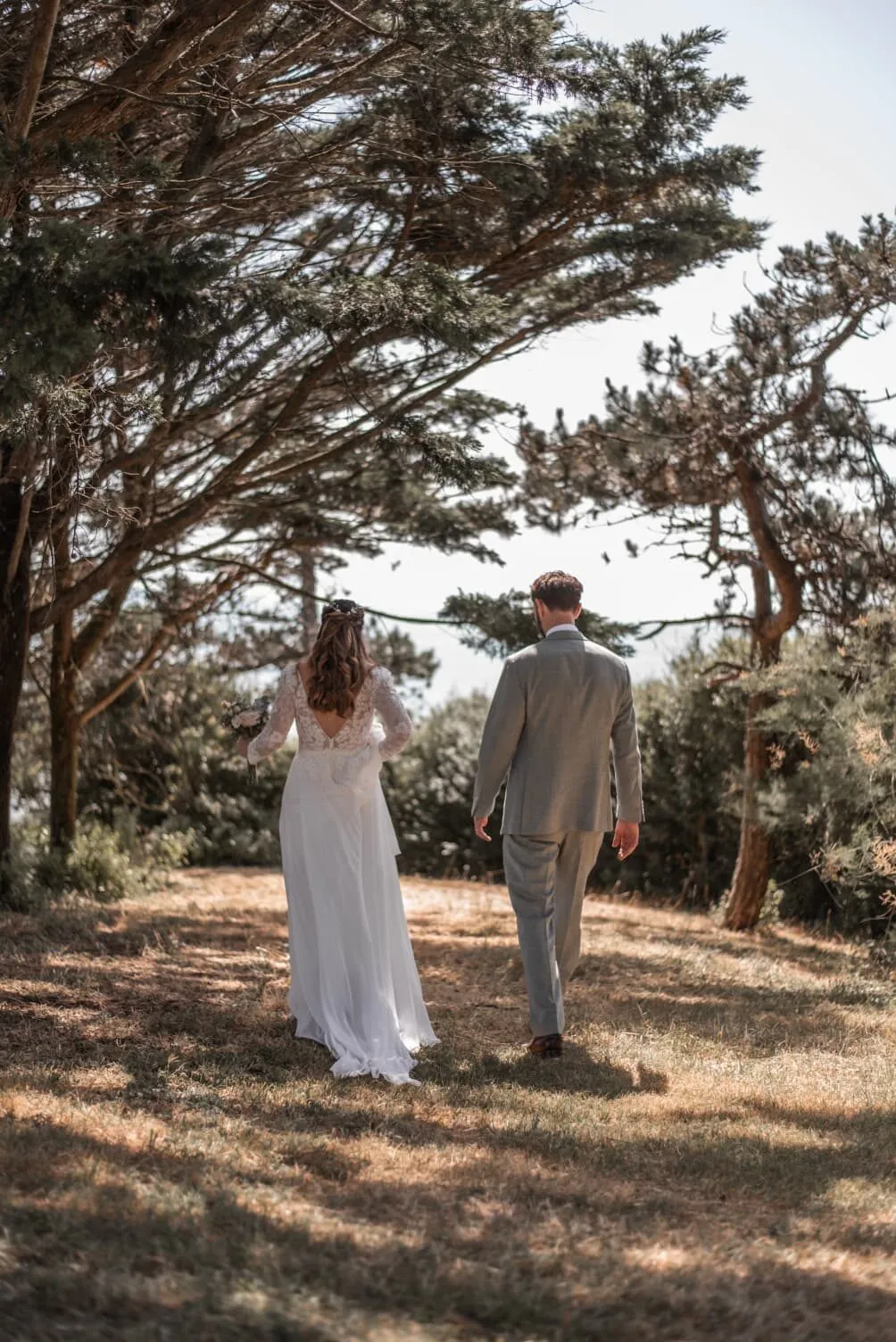 Les mariés marchent sous les pins